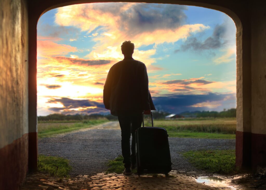 Man holding bag looking at sunset