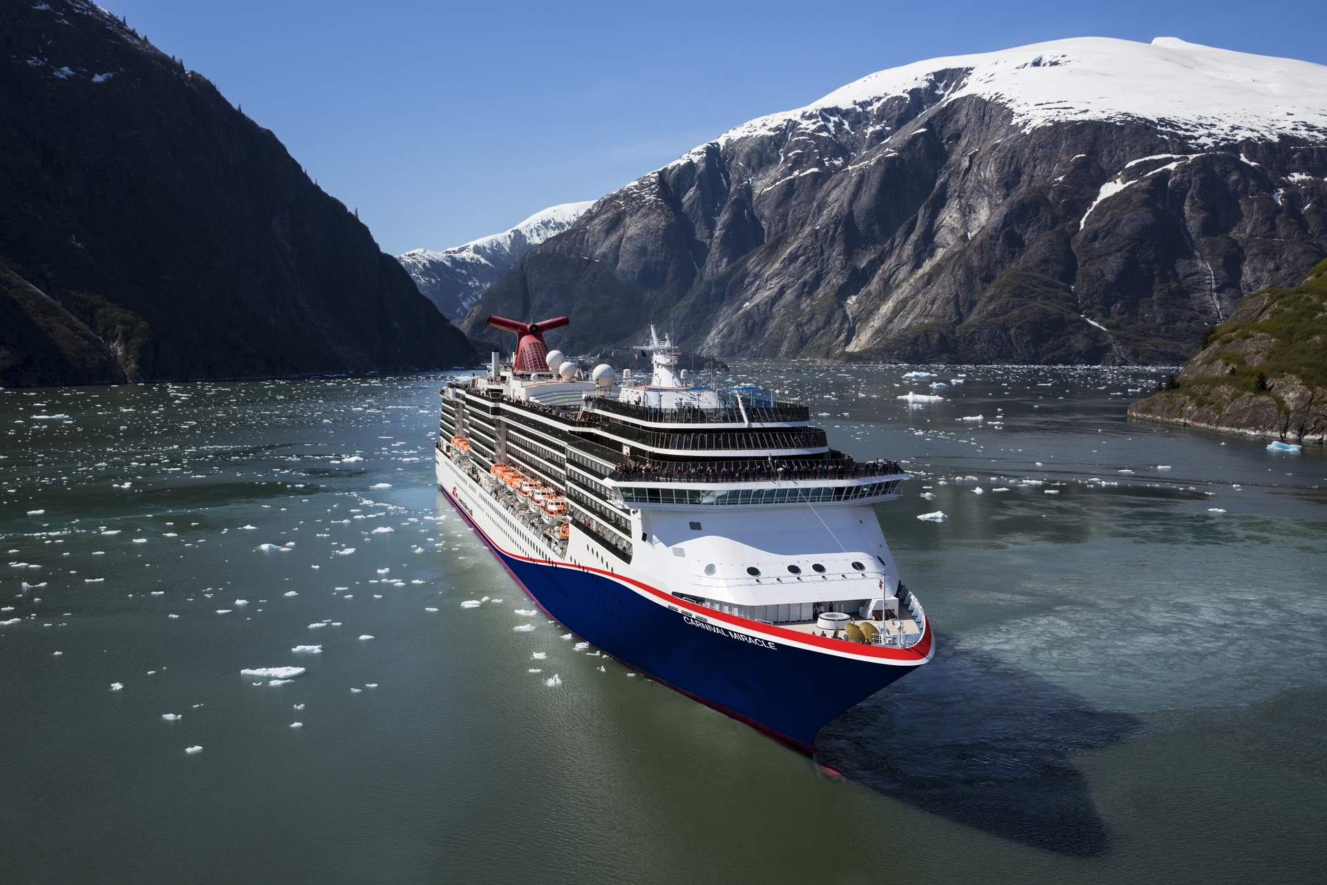 A cruise ship with snow-covered mountains in the background