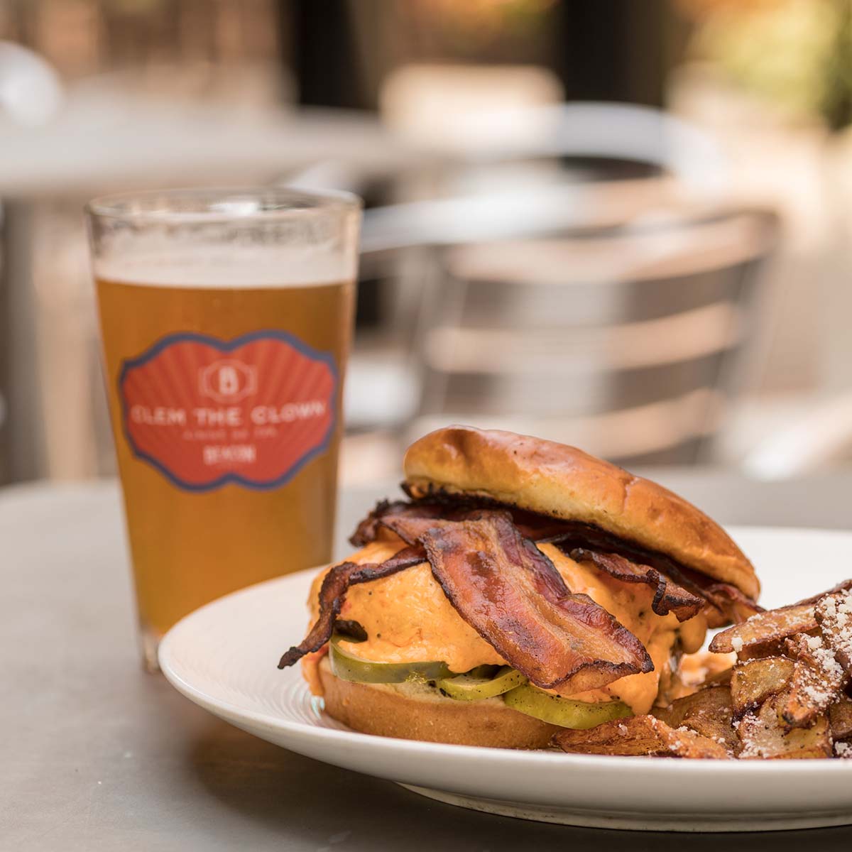 A bacon cheeseburger and a beer, on a table at Mare Sol.